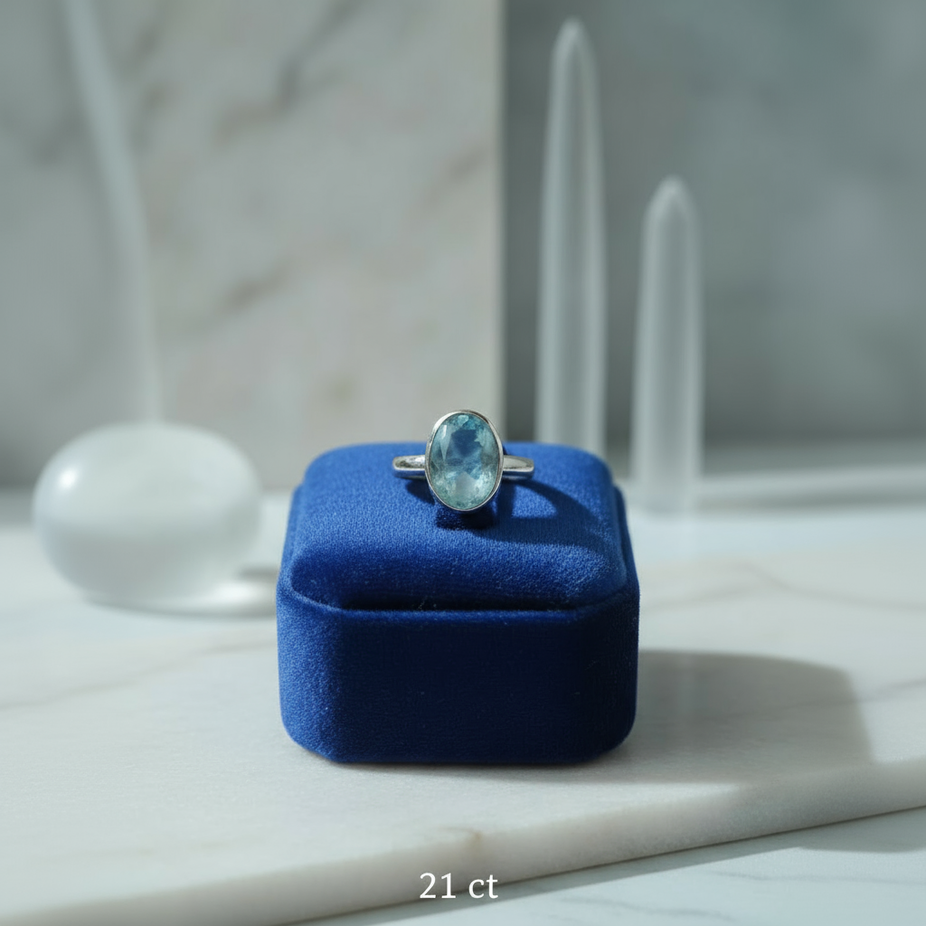 Ring with a blue gemstone on a blue cushion in a blurred indoor setting