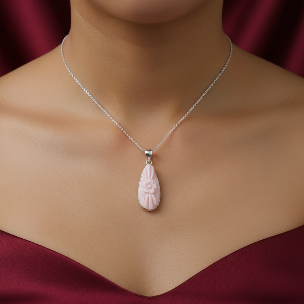 Necklace with a pink pendant on a mannequin against a red background