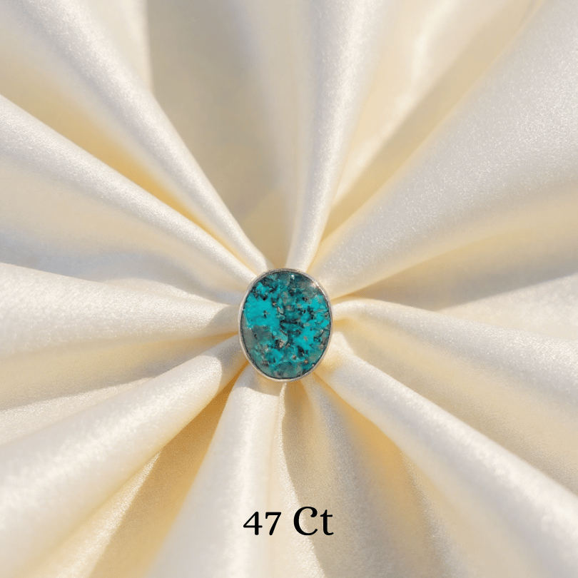 Turquoise stone on a white fabric background with '47 Ct' text