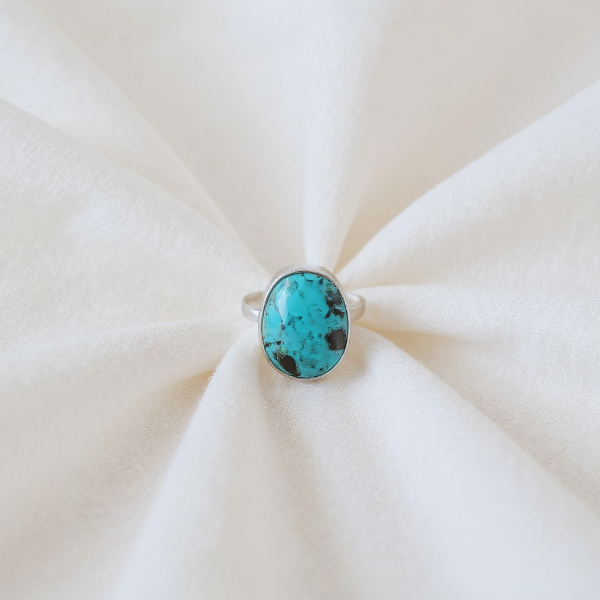 Turquoise ring on a white fabric background