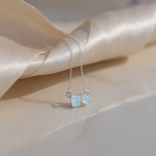 Necklace with two opal stones on a beige fabric background