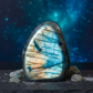 Labradorite stone with blue and beige patterns on a dark background