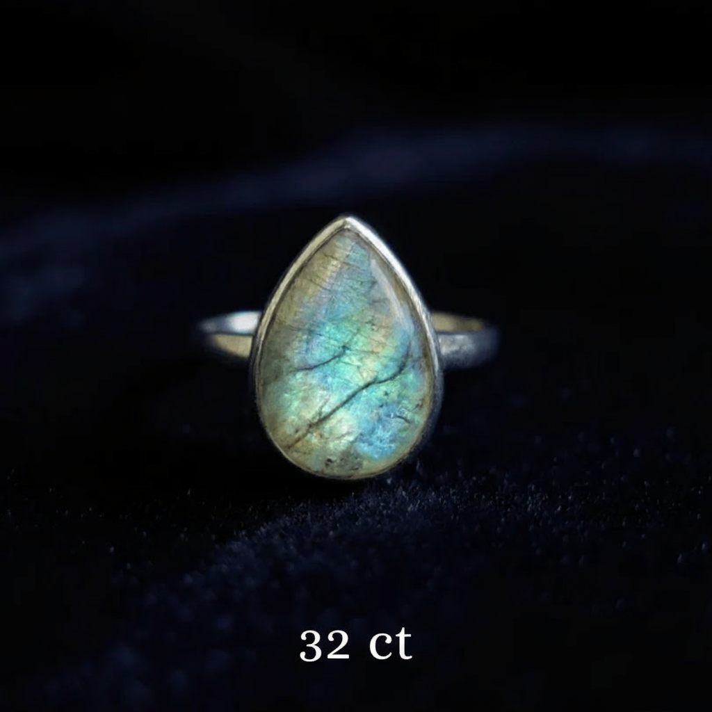 Teardrop-shaped labradorite ring on a dark background with '32 ct' text.
