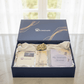 Gift set with a gratitude journal, card, and rock in a decorative box on a light background