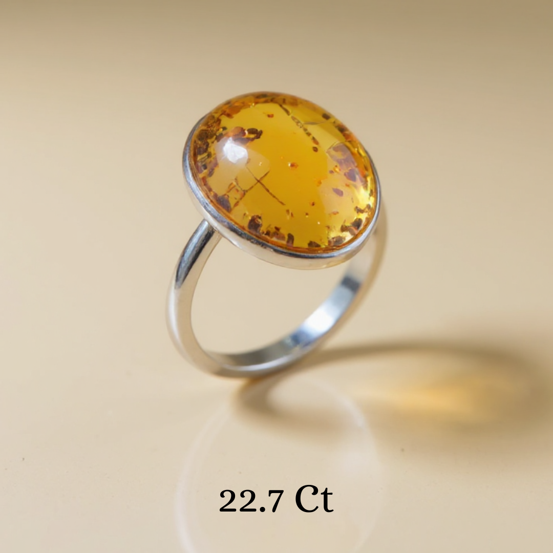 Ring with a large amber stone on a beige background