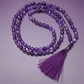 ametrine necklace with a tassel on a purple background