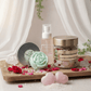 Assorted beauty products including a jar, bottle, and bath bombs on a wooden tray with a soft background.