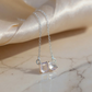 Silver necklace with a clear gemstone pendant on a marble surface