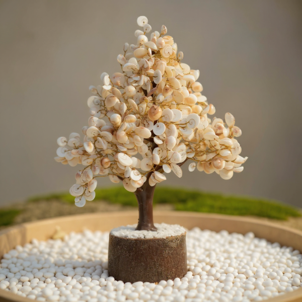 Decorative tree made of small stones on a bed of white pebbles with a blurred background