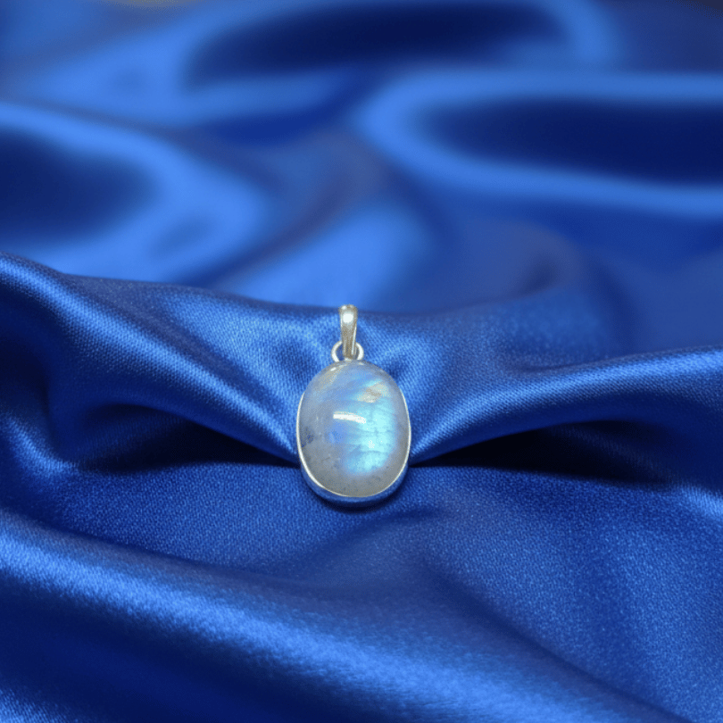 rainbow moonstone pendant on a blue satin fabric