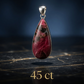 Teardrop-shaped red stone pendant with silver setting on a dark background