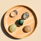 Wooden tray with four colorful crystal stones on a beige background