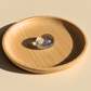 Wooden bowl with a clear crystal ball on a beige background