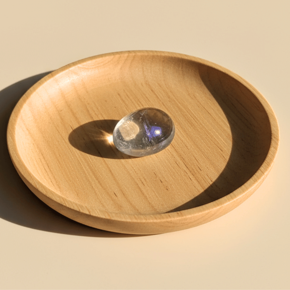 Wooden bowl with a clear crystal ball on a beige background
