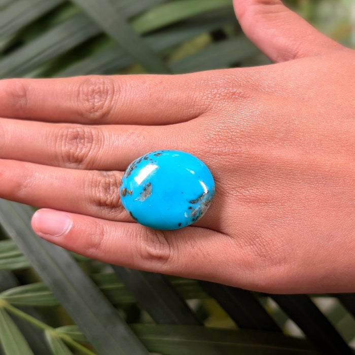 Turquoise stone on a hand with a natural background