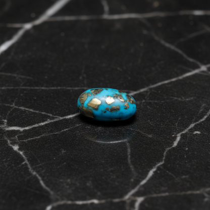 Turquoise stone with gold inclusions on a black textured surface